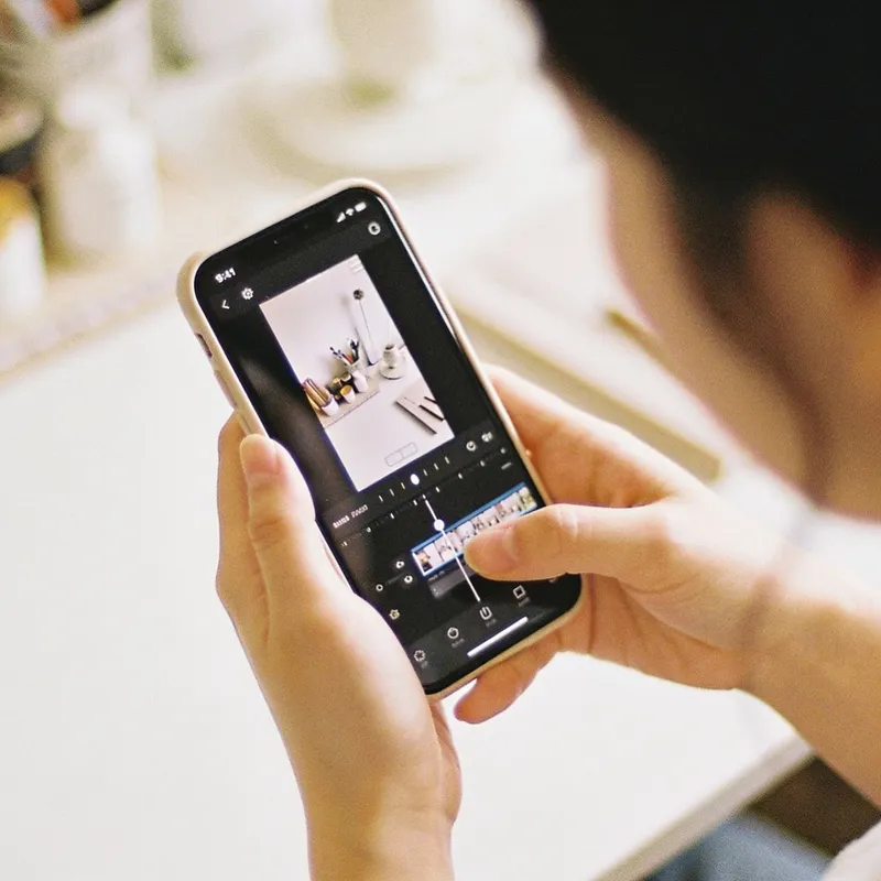 Hands editing a short video on a phone