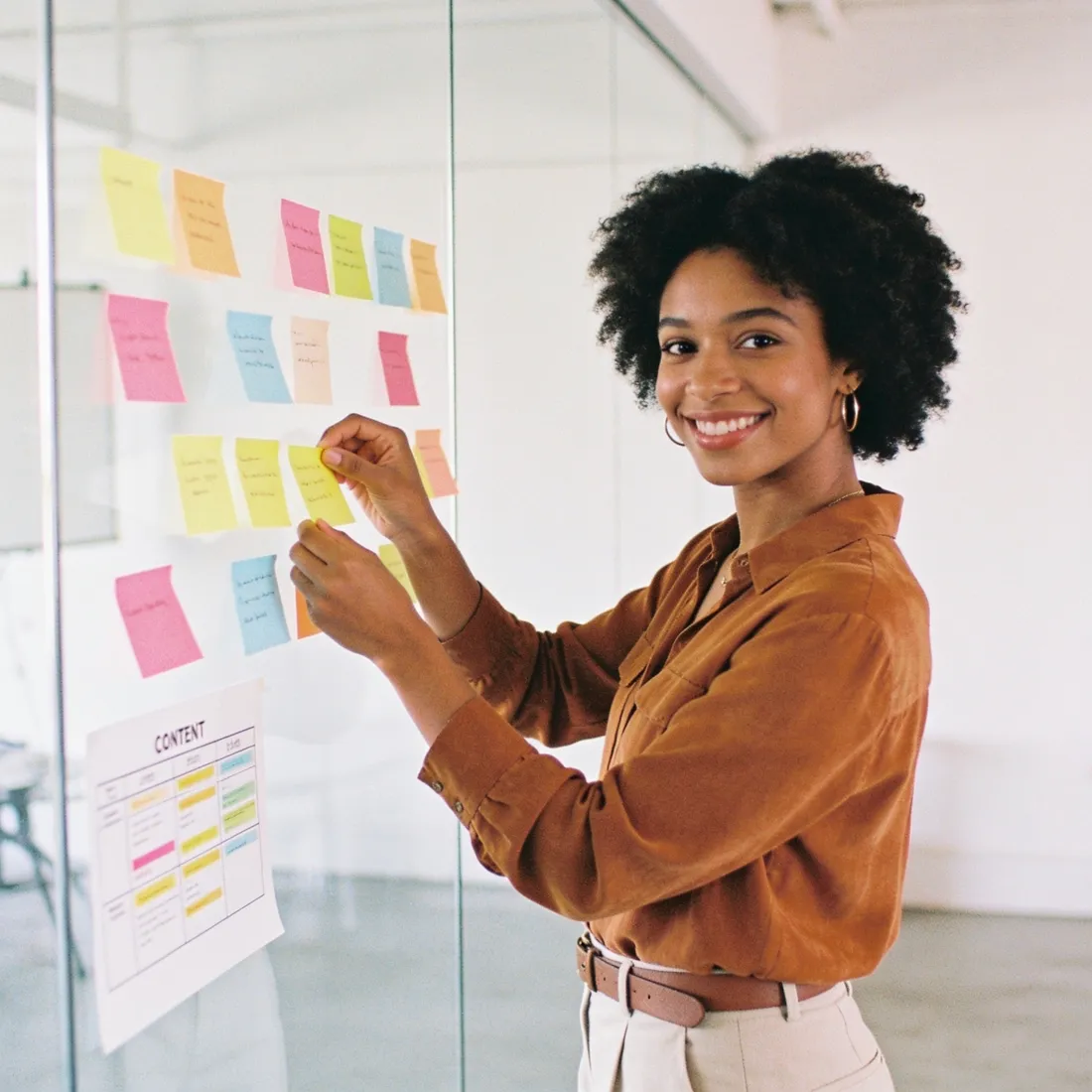 A content strategist arranging colourful topic notes on a studio wall